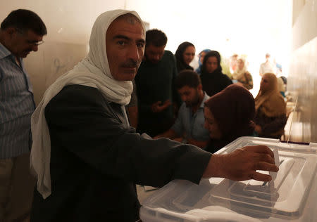 A man casts his ballot inside a polling station in Qamishli, Syria September 22, 2017. REUTERS/Rodi Said