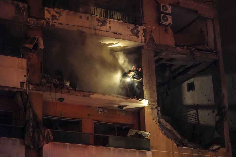 People search for survivors inside an apartment following a massive explosion in the southern suburb of Beirut, Lebanon, Tuesday, Jan. 2, 2024. (AP Photo/Hassan Ammar)