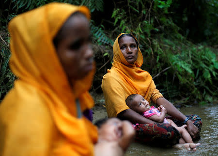 Rohingya refugee women rest in a stream after crossing the Bangladesh-Myanmar border in Cox's Bazar, Bangladesh September 8, 2017. REUTERS/Danish Siddiqui