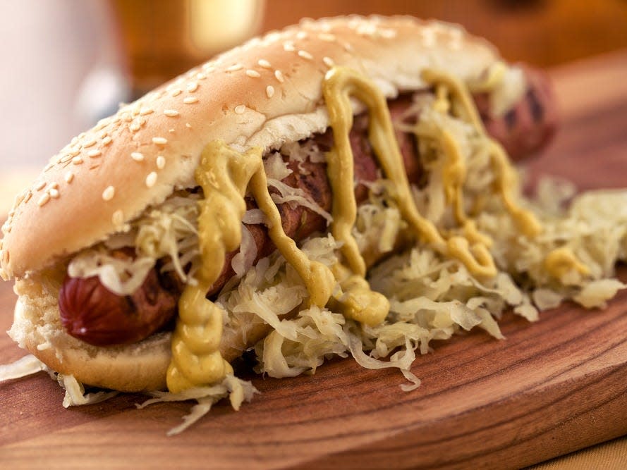 hot dog mustard sauerkraut on wooden board