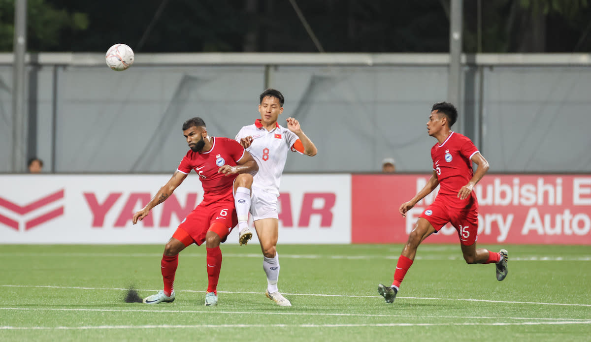 Singapore's M. Anumanthan (left) and Shah Shahiran (right) battle for possession with Vietnam's Do Hung Dung in their AFF Mitsubishi Electric Cup match. (PHOTO: Football Association of Singapore)