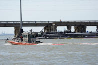 An spill boom is moved into position to contain a leak from a barge that crashed into the Pelican Island Bridge, Wednesday, May 15, 2024, in Galveston, Texas. (AP Photo/David J. Phillip)