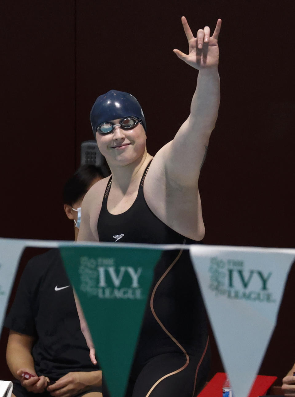 Yale's Iszac Henig acknowledges cheers from the crowd during introductions for the 50-yard freestyle final at the Ivy League women's swimming and diving championships at Harvard University, Thursday, Feb. 17, 2022, in Cambridge, Mass. Henig, who is transitioning to male but has not begun hormone treatments yet, is swimming for Yale's women's team. (AP Photo/Mary Schwalm)