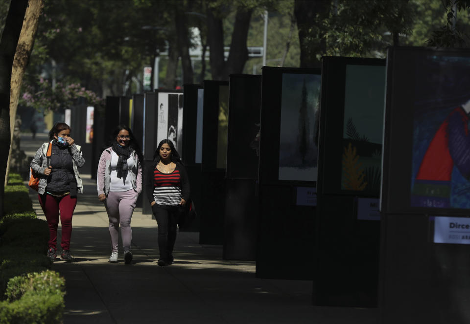 Pedestrians, one wearing a face mask, walk along an almost empty Paseo de la Reforma street in Mexico City, Tuesday, June 2, 2020, amid the new coronavirus pandemic. While the federal government’s nationwide social distancing rule formally ended Monday, it is urging people in so-called “red” zones to maintain most of those measures — and so many people are falling ill and dying each day that those zones cover nearly the whole country. (AP Photo/Fernando Llano)