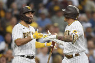 San Diego Padres' Manny Machado (13), right, is congratulated by Eric Hosmer (30) after hitting a solo home run during the first inning of a baseball game against the Los Angeles Dodgers Wednesday, June 23, 2021, in San Diego. (AP Photo/Denis Poroy)