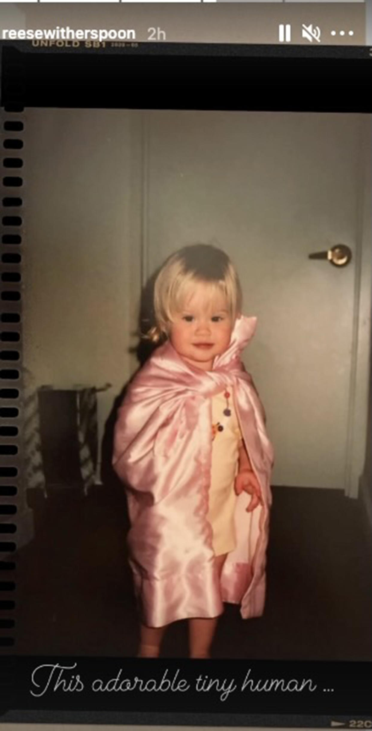 In another throwback, Ava is seen wearing a shimmery pink blanket as a cape. (reesewitherspoon/ Instagram)