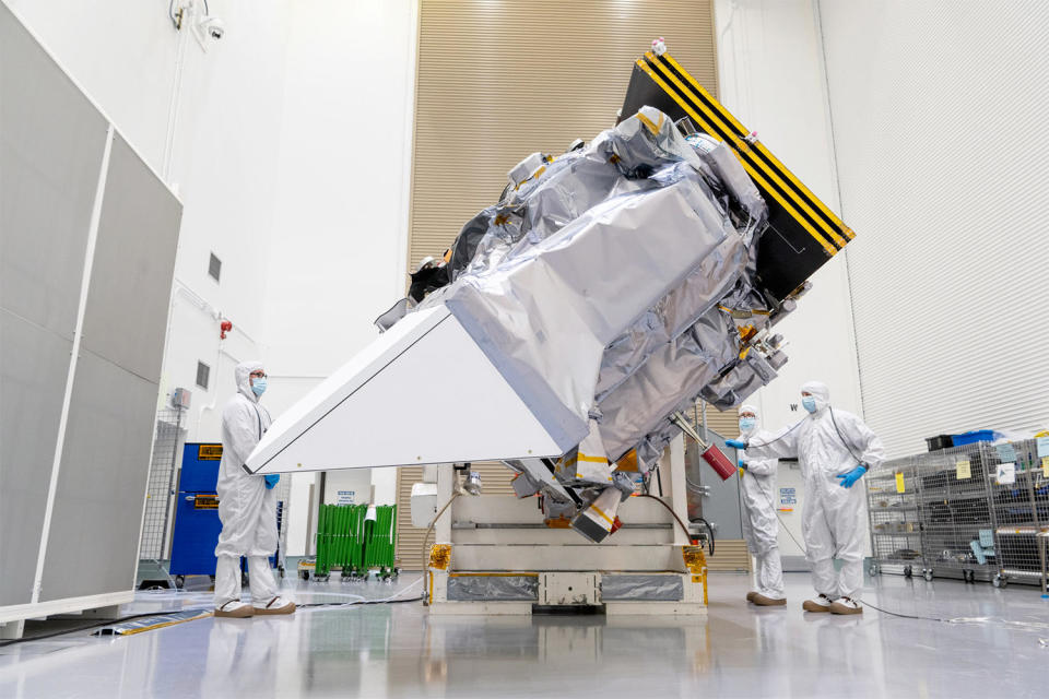 The PACE satellite, its solar array folded at top right, is seen during pre-flight tests and check out in an environmentally controlled 