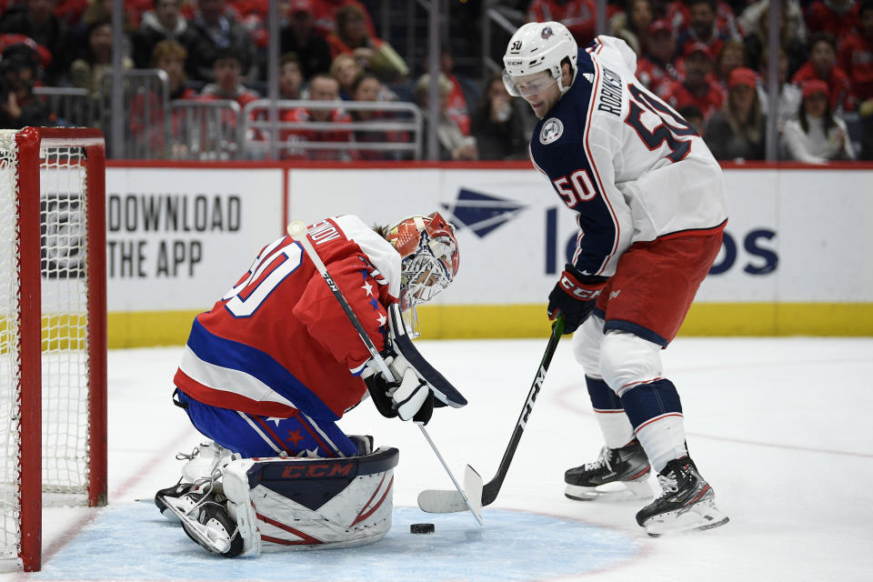 Washington Capitals goaltender Ilya Samsonov (30), of Russia, defends the net next to Columbus Blue Jackets left wing Eric Robinson (50) during the first period of an NHL hockey game Friday, Dec. 27, 2019, in Washington. (AP Photo/Nick Wass)