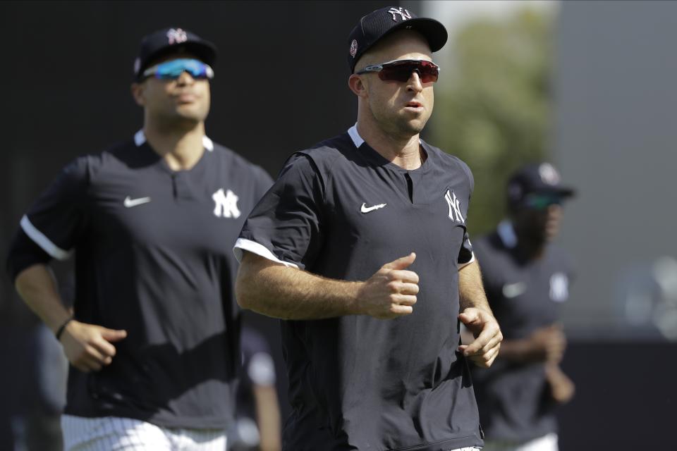 New York Yankees' Brett Gardner, center, and Giancarlo Stanton, left, run on the field during a spring training baseball workout Tuesday, Feb. 18, 2020, in Tampa, Fla. (AP Photo/Frank Franklin II)