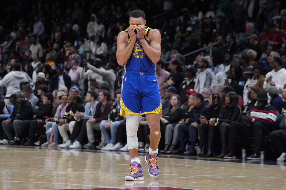 Golden State Warriors guard Stephen Curry wipes his face with his jersey in overtime in an NBA basketball game against the Atlanta Hawks Saturday, Feb. 3, 2024, in Atlanta. (AP Photo/John Bazemore)