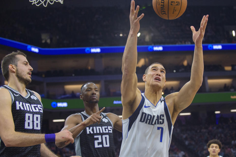 Sacramento Kings forwards Nemanja Bjelica (88) and Harry Giles III (20) defend as Dallas Mavericks forward Dwight Powell (7) grabs a rebound during the first quarter of an NBA basketball game in Sacramento, Calif., Wednesday, Jan. 15, 2020. (AP Photo/Randall Benton)