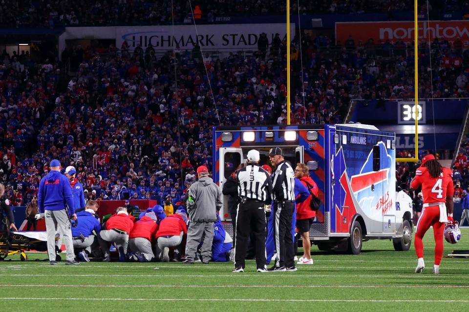 An ambulance waits on the field as medical staff attend to Buffalo Bills running back Damien Harris.