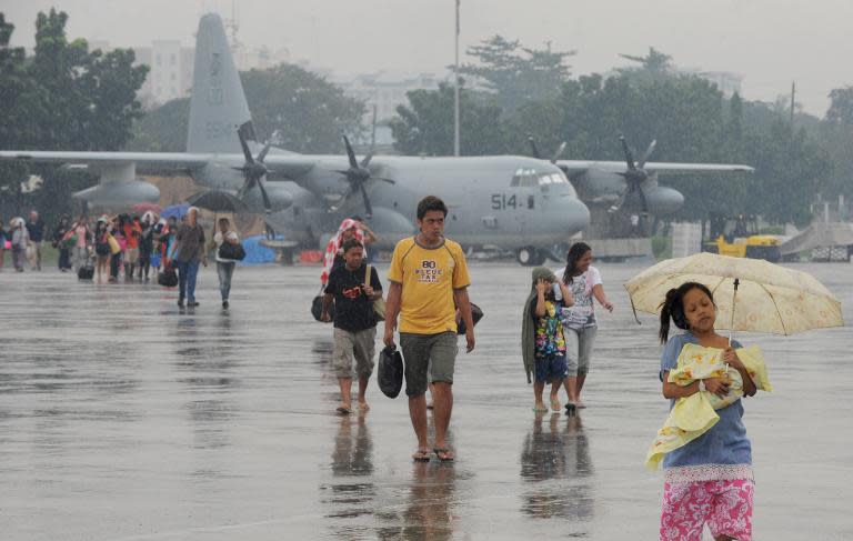 People who survived the wrath of Super Typhoon Haiyan in the central coastal city of Tacloban disembark from a US KC-130 military cargo plane that flew them out of the city to Manila on November 13, 2013