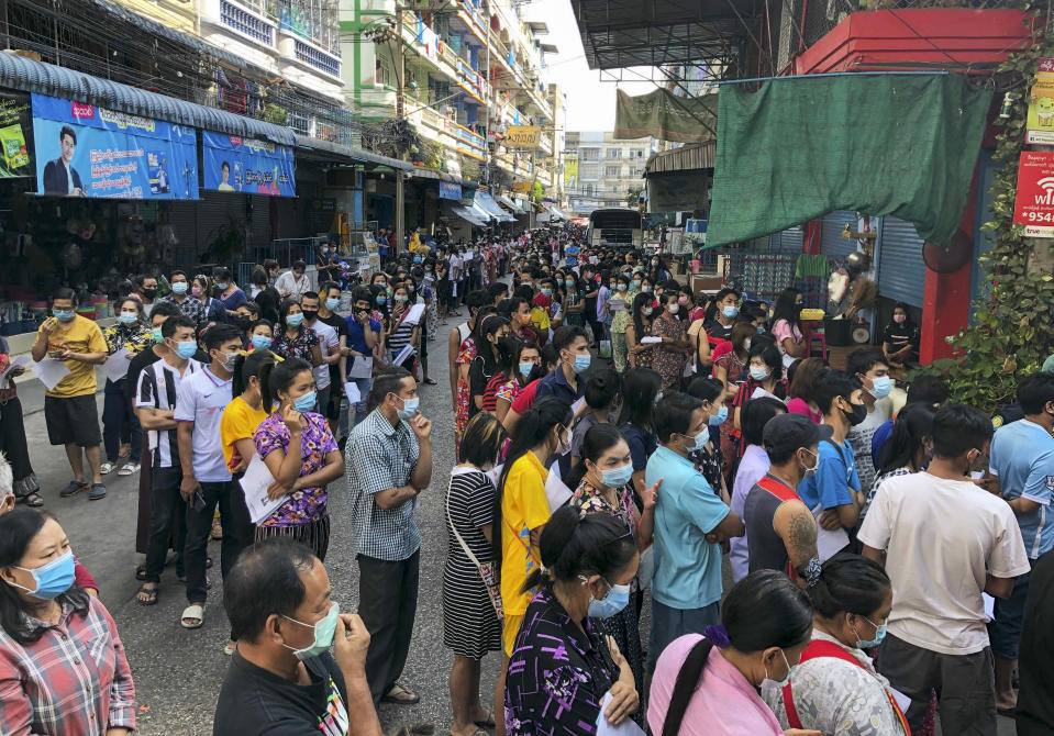 People stand in lines to get COVID-19 tests in Samut Sakhon, South of Bangkok, Thailand, Sunday, Dec. 20, 2020. Thailand reported more than 500 new coronavirus cases on Saturday, the highest daily tally in a country that had largely brought the pandemic under control. (AP Photo/Jerry Harmer)