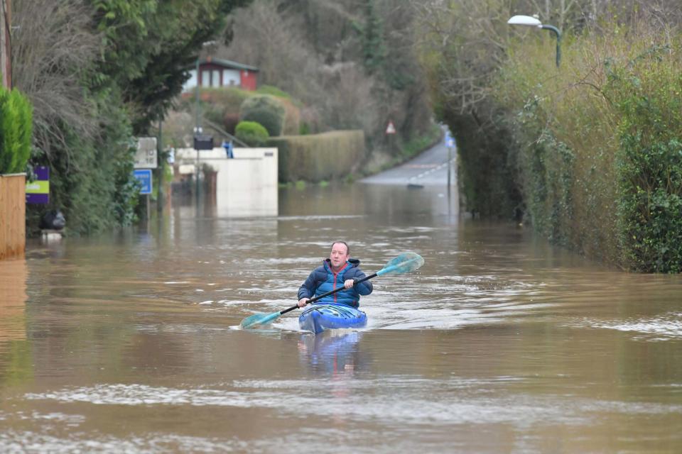 A canoeist makes their way down a road in Monmouth, in the aftermath of Storm Dennis (PA)