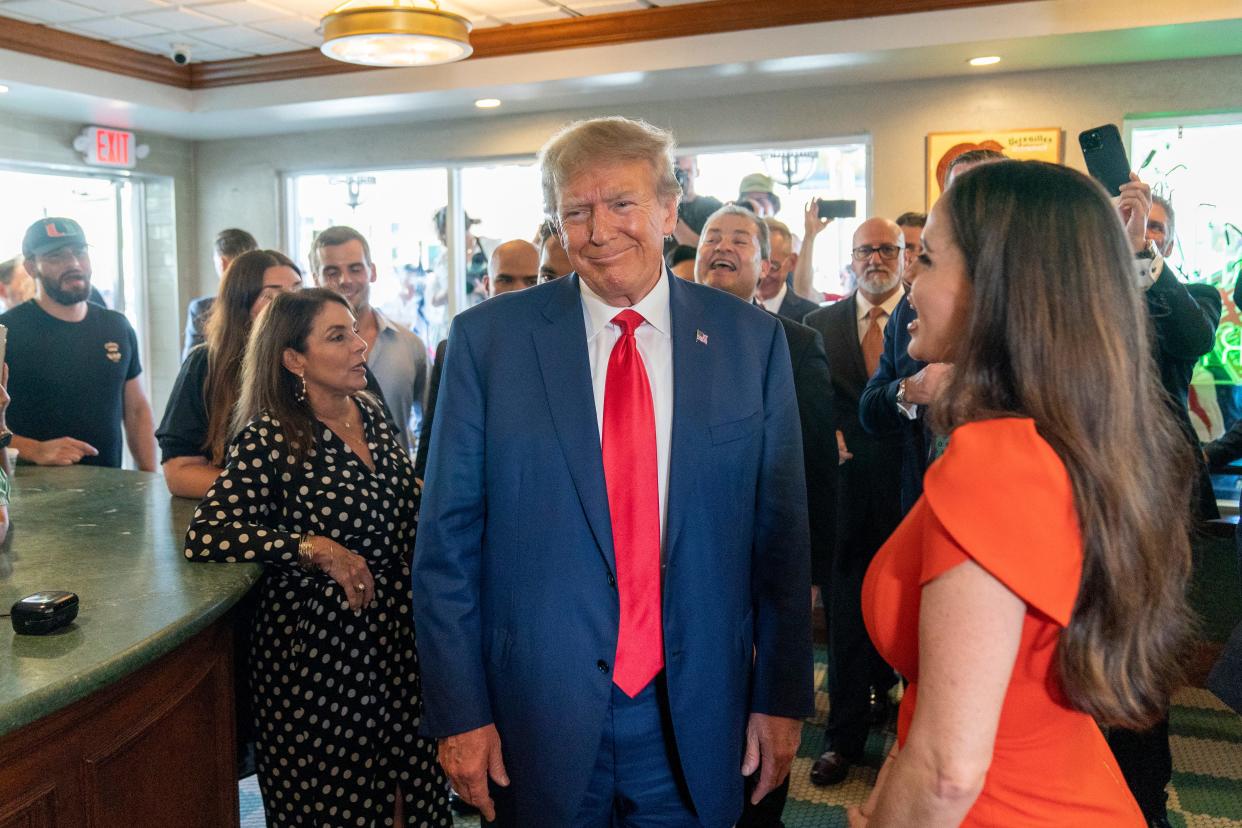 Former President Donald Trump smiles at the cameras as he visits Versailles restaurant on Tuesday, June 13, 2023, in Miami. Trump appeared in federal court Tuesday on dozens of felony charges accusing him of illegally hoarding classified documents and thwarting the Justice Department's efforts to get the records back.