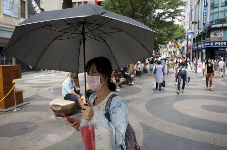 A woman wearing a mask to prevent contracting Middle East Respiratory Syndrome (MERS) walks in central Seoul, South Korea, June 15, 2015. REUTERS/Kim Hong-Ji