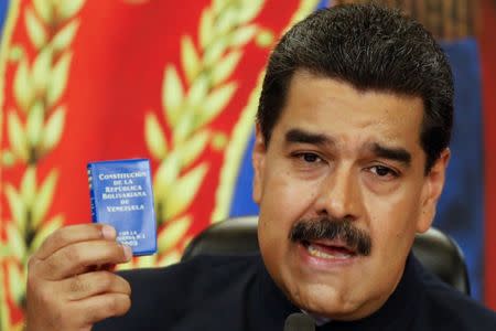 Venezuela's President Nicolas Maduro holds a copy of the National Constitution while he talks to the media during a news conference at Miraflores Palace in Caracas, Venezuela October 17, 2017. REUTERS/Carlos Garcia Rawlins