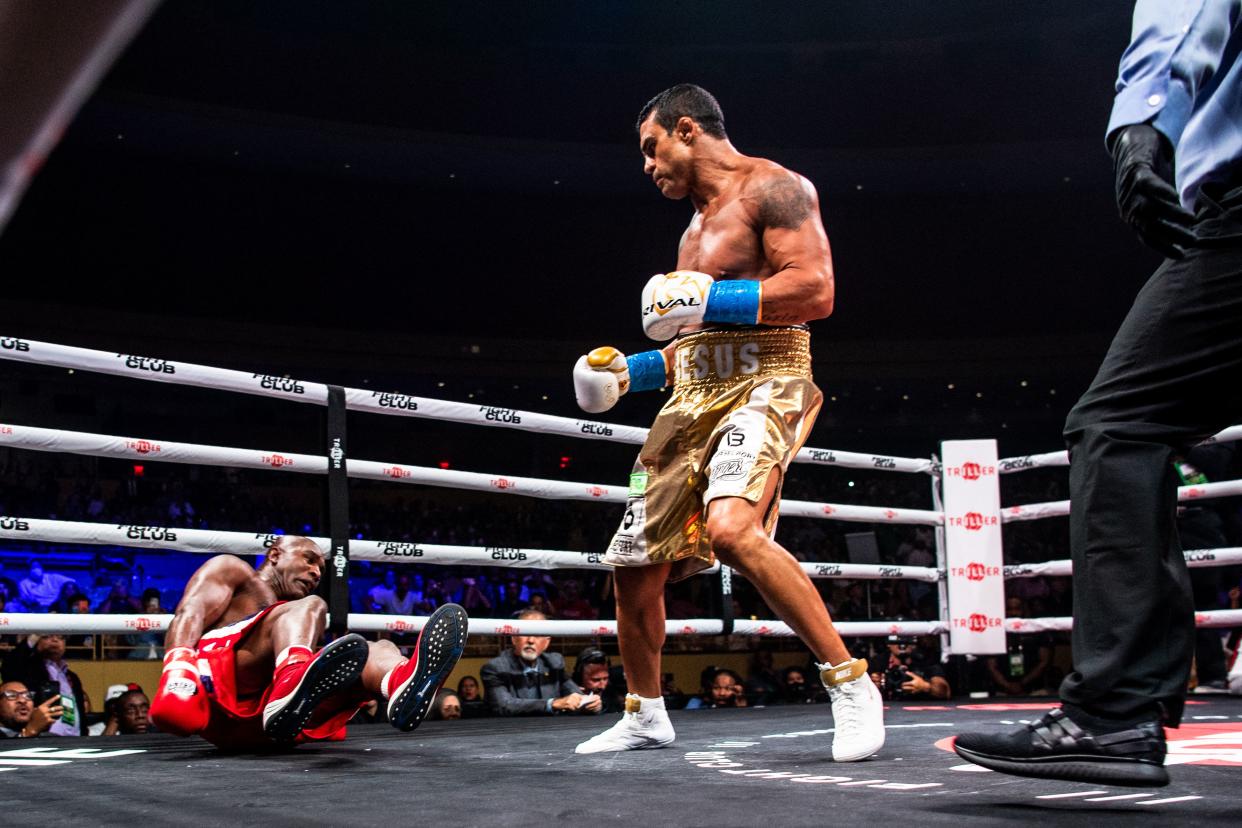 US former professional boxer Evander Holyfield falls during a fight against Brazilian martial artist Vitor Belfort