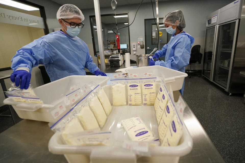 Milk lab technicians Welney Huang, right, and Nguyen Nguyen, process breast milk at the University of California Health Milk Bank, Friday, May 13, 2022, in San Diego. The U.S. baby formula shortage has sparked a surge of interest among moms who want to donate breast milk to help bridge the supply gap as well as those seeking to keep their babies fed. (AP Photo/Gregory Bull)