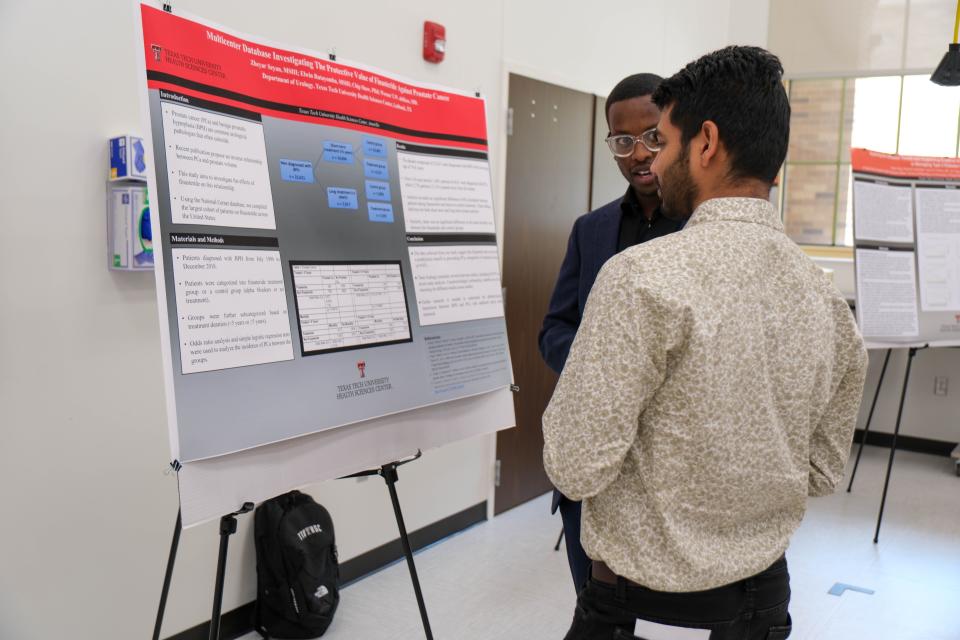 Researchers discuss a poster research presentation Friday at the inaugural Amarillo Research Symposium at the Texas Tech School of Veterinary Medicine in Amarillo.