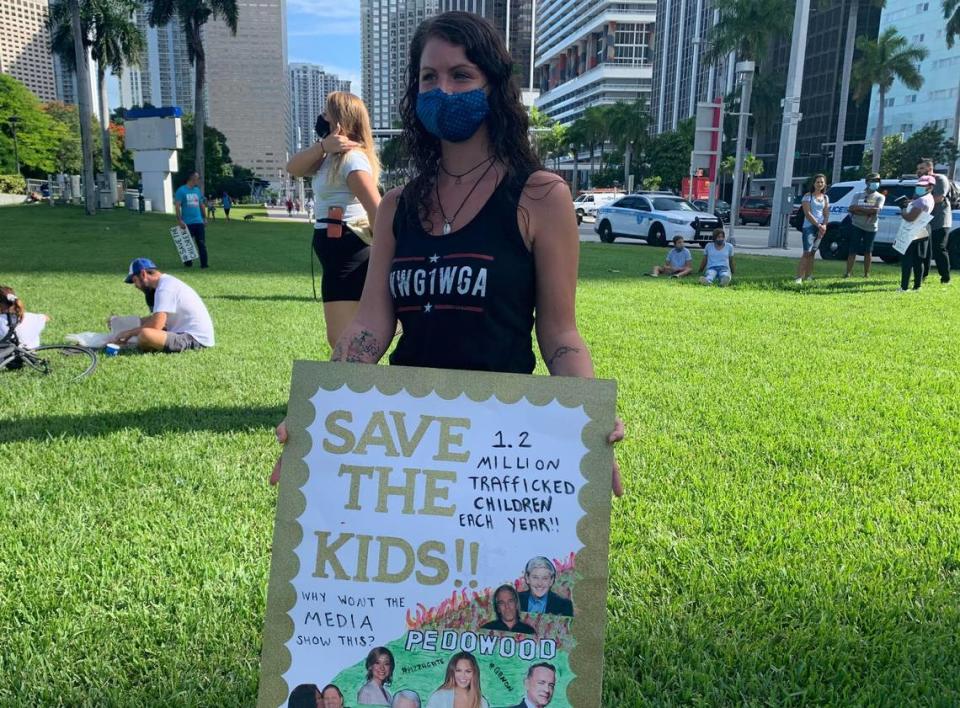 Jenn Luizzi, a 27-year-old QAnon supporter from Deerfield Beach, holds a sign at Bayfront Park during a child sex trafficking rally in Miami on Aug. 22, 2020.