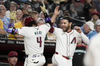 Arizona Diamondbacks second base Ketel Marte (4) celebrates with Eugenio Suárez, right, after hitting a home run against the Chicago Cubs during the first inning of a baseball game Wednesday, April 17, 2024, in Phoenix. (AP Photo/Darryl Webb)