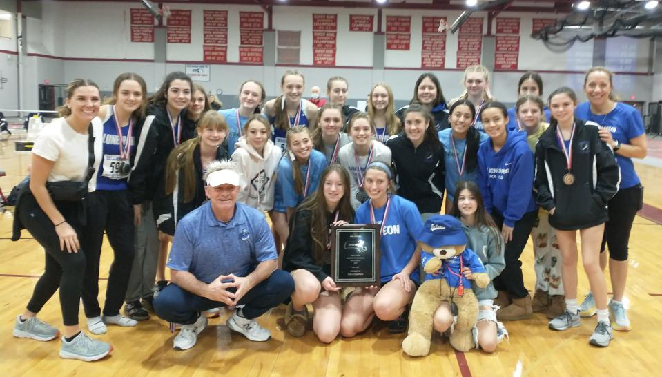 Athletes and coaches from the Lunenburg girls' indoor track team celebrate the win at the District E Division 2 championship at Fitchburg High.