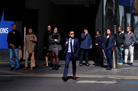 FILE PHOTO: Pedestrians prepare to walk across a main road in front of a construction site in the central business district (CBD) of Sydney in Australia, November 8, 2018.REUTERS/David Gray/File Photo