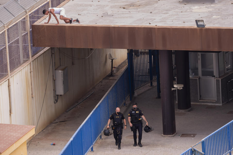 An unaccompanied minor who crossed into Spain hides atop of a rooftop in the Spanish enclave of Ceuta, next the border between Spain and Morocco, Wednesday, May 19, 2021. Social services for the small city perched on an outcropping in the Mediterranean buckled under the strain after more than 8,000 people crossed into Spanish territory during the previous two days. (AP Photo/Bernat Armangue)