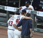 Atlanta Braves manager Brian Snitker and a trainer help pitcher Mike Soroka off the field with an apparent injury, during the third inning of the team's baseball game against the New York Mets, Monday, Aug. 3, 2020, in Atlanta. (Curtis Compton/Atlanta Journal-Constitution via AP)