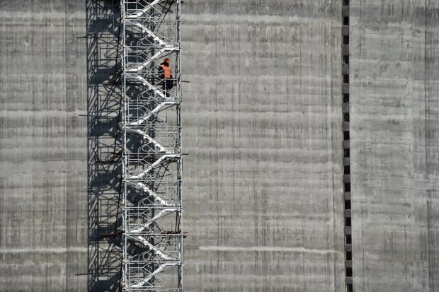 A worker standing on the stairs of a natural gas reservoir at the port of Sabetta in the Arctic circle. The lack of reporting requirements on fly-in workers can leave them exposed to discrimination and exploitation, said Alexandra Middleton, an assistant professor at the University of Oulu in Finland.