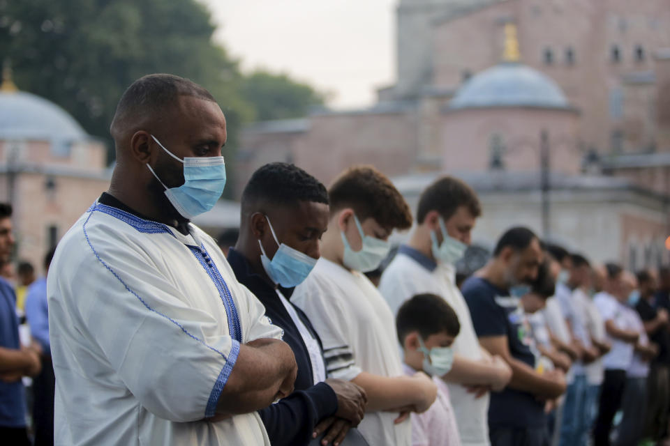 Muslims offer prayers during the first day of the Eid al-Adha, outside the iconic Haghia Sophia mosque in the historic Sultan Ahmed district of Istanbul, Tuesday, July 20, 2021. The major Muslim holiday, at the end of the hajj pilgrimage to Mecca, is observed around the world by believers and commemorates prophet Abraham's pledge to sacrifice his son as an act of obedience to God. (AP Photo/Mucahid Yapici)