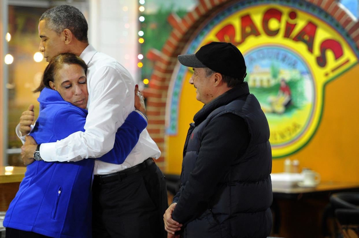 President Barack Obama hugs Lilia Yepez as he visits with Carlos Yepez during a visit Dec. 9, 2014, to La Hacienda Taqueria on Nolensville Pike