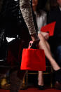 <p>A model carries a red, furry, eyelet bag from the Christian Siriano FW18 show. (Photo: Getty Images) </p>