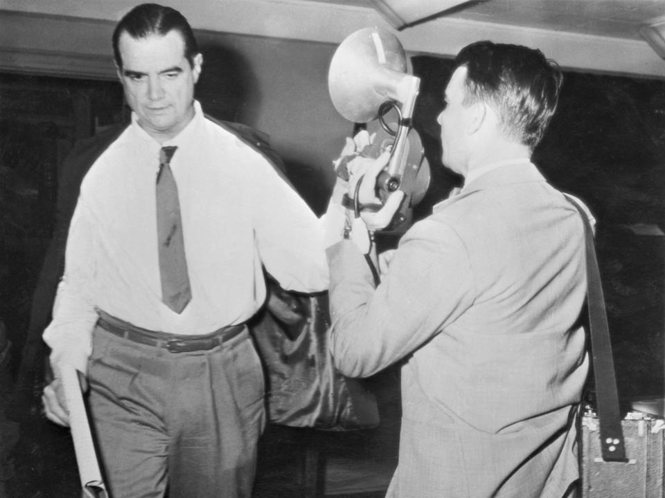 Howard Hughes blocks a camera in 1952.