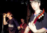 THEN: (L-R) Liam Gallagher and Noel Gallagher of Oasis perform in New York City in 1994. (Photo by Steve Eichner/WireImage)