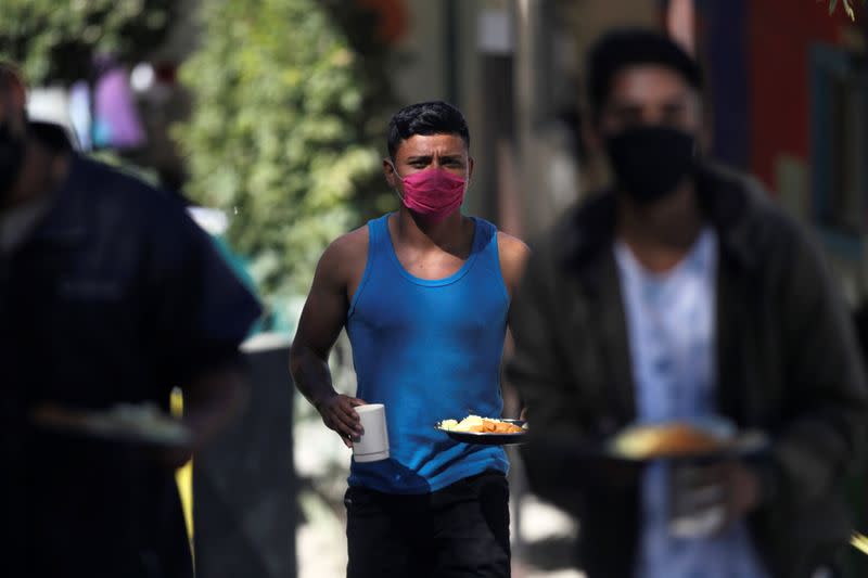 Migrant walks with food in their hands at Posada Belen migrant shelter, before being closed due to an outbreak of the coronavirus disease COVID-19, in Saltillo