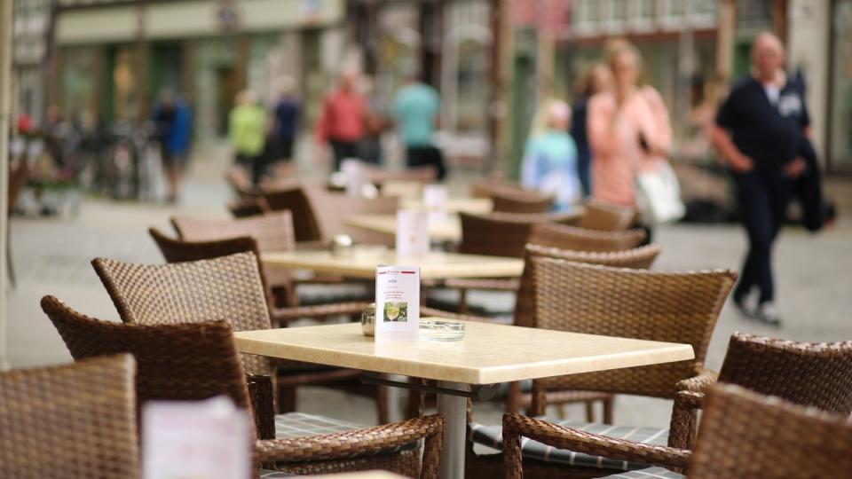 Tische und Stühle stehen vor einem Hotel am Marktplatz für Gäste bereit.