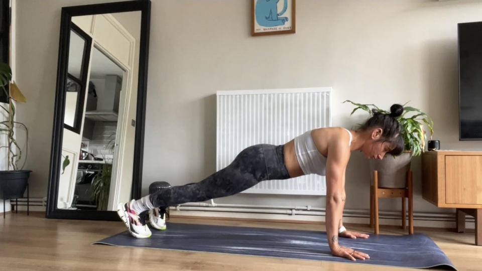 Writer Sam performing a push-up from the push-up starting position on yoga mat