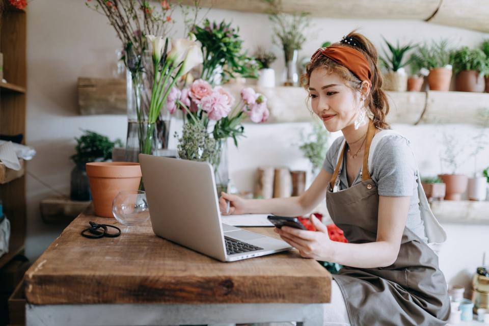 small business owner uses computer while working in florist shop