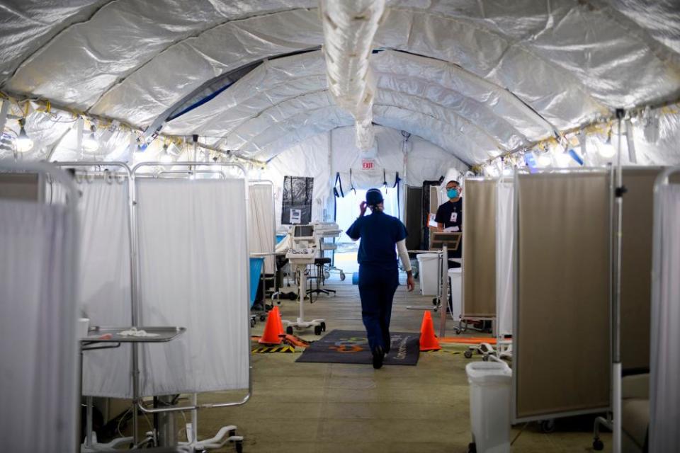 Kennoka Williamson, a registered nurse, attends to patients in a Covid-19 triage area set up in a field hospital tent outside the hospital.