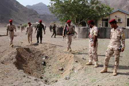 Soldiers are seen at the scene of the blast after a missile attack on a military parade during a graduation ceremony for newly recruited troopers in Aden