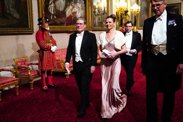 Labour Party leader Sir Keir Starmer in white tie and his wife Victoria Starmer walk through the Palace during the state banquet at Buckingham Palace for the South African state visit in 2022 