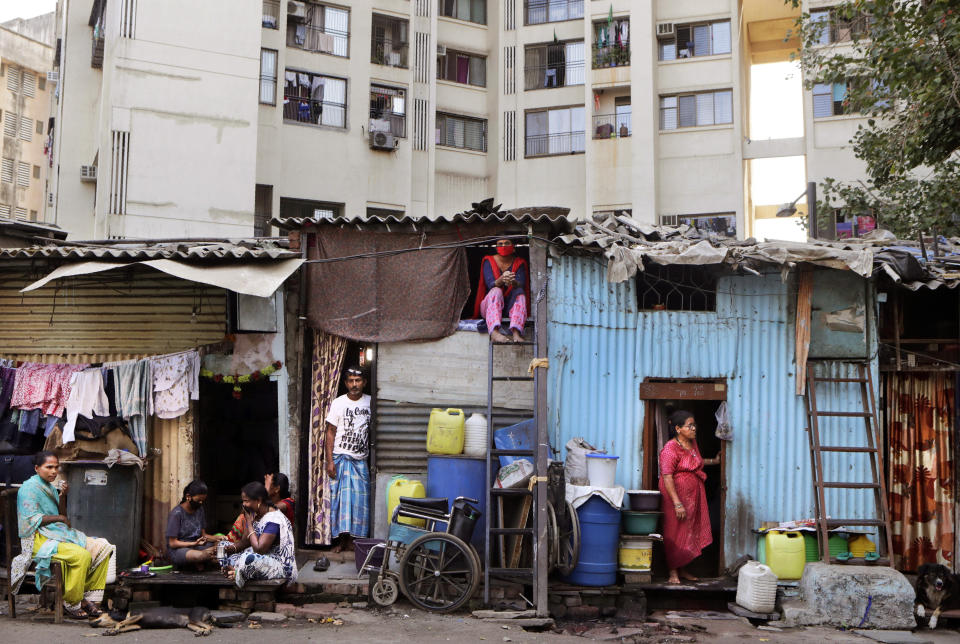 Impoverished Indians rest by their shanties at Dharavi, one of Asia's largest slums, during lockdown to prevent the spread of the coronavirus in Mumbai, India, Friday, April 3, 2020. A nationwide lockdown announced last week by Prime Minister Narendra Modi led to a mass exodus of migrant workers from cities to their villages, often on foot and without food and water, raising fears that the virus may have reached to the countryside, where health care facilities are limited. Experts say that local spreading is inevitable in a country where tens of millions of people live in dense urban areas with irregular access to clean water, and that the exodus of the migrants will burden the already strained health system. (AP Photo/Rajanish Kakade)