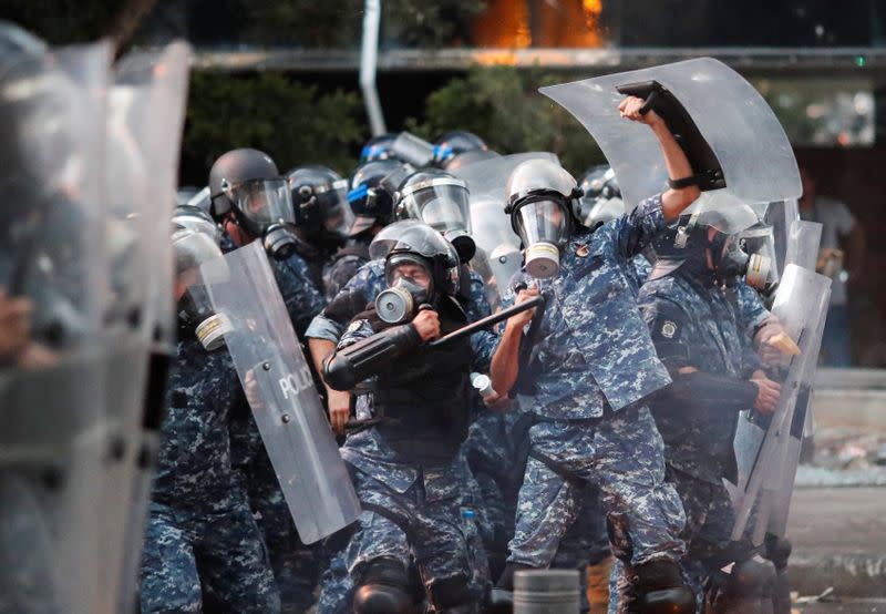 Police officers form a line during anti-government protests that have been ignited by a massive explosion in Beirut