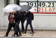 People walk in front of an electronic stock board showing Japan's Nikkei index at a securities firm, Wednesday, Oct. 9, 2024, in Tokyo. (AP Photo/Eugene Hoshiko)