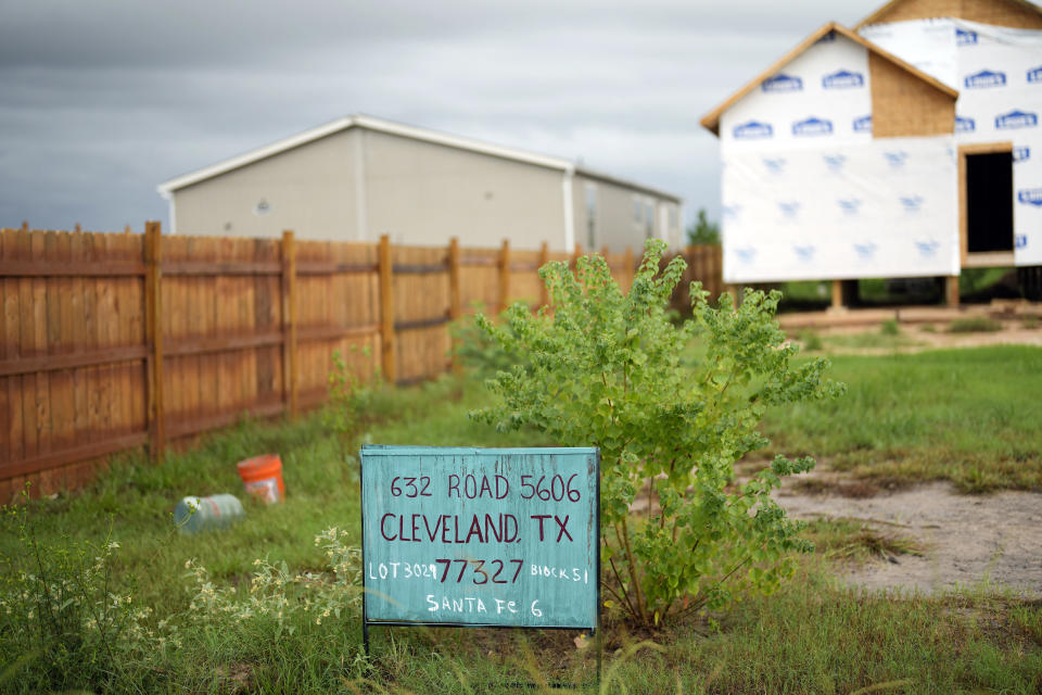 A new home under construction is shown next to a mobile home in the Colony Ridge development Tuesday, Oct. 3, 2023, in Cleveland, Texas. For weeks in Texas, conservative media and GOP activists have been pushing unsubstantiated claims that Colony Ridge has become a magnet for immigrants living in the U.S. illegally and that cartels control pockets of the neighborhood. (AP Photo/David J. Phillip)