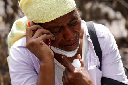 Eufemia Garcia, 48, who lost 50 members of her family during the eruption of the Fuego volcano, cries on the phone while searching for her family in San Miguel Los Lotes in Escuintla, Guatemala, June 11, 2018. REUTERS/Carlos Jasso