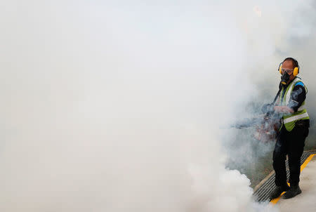 A worker fogs the common area of a public housing estate at an area where locally transmitted Zika cases were discovered in Singapore